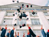 group of fresh graduates students throwing their academic hat in the air